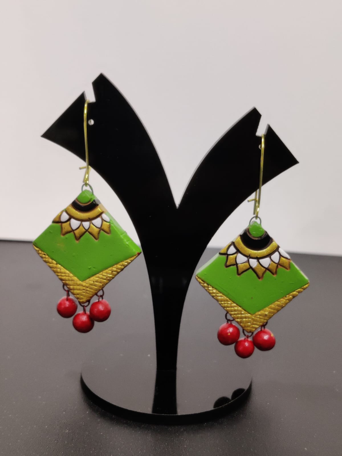 Terracotta Fusion: Vibrant Green and Red Earrings on Black Stand